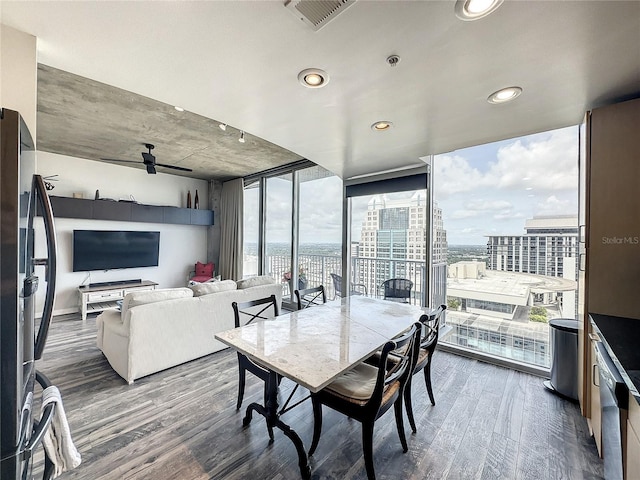 dining room featuring a city view, expansive windows, a ceiling fan, wood finished floors, and visible vents