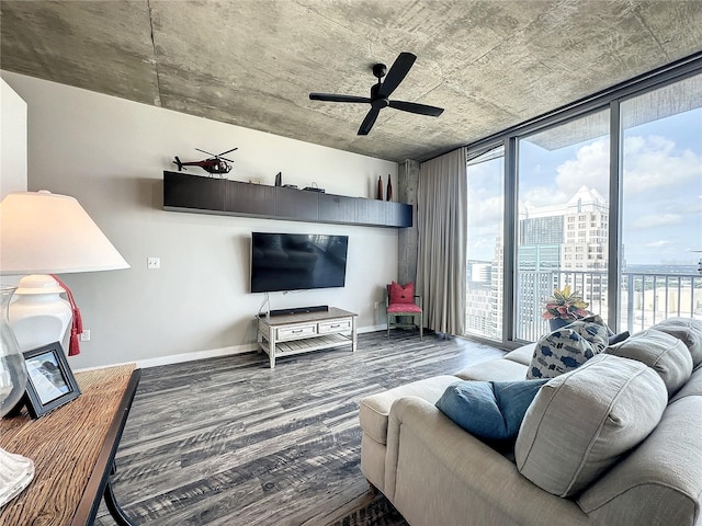 living area with a ceiling fan, baseboards, expansive windows, and wood finished floors