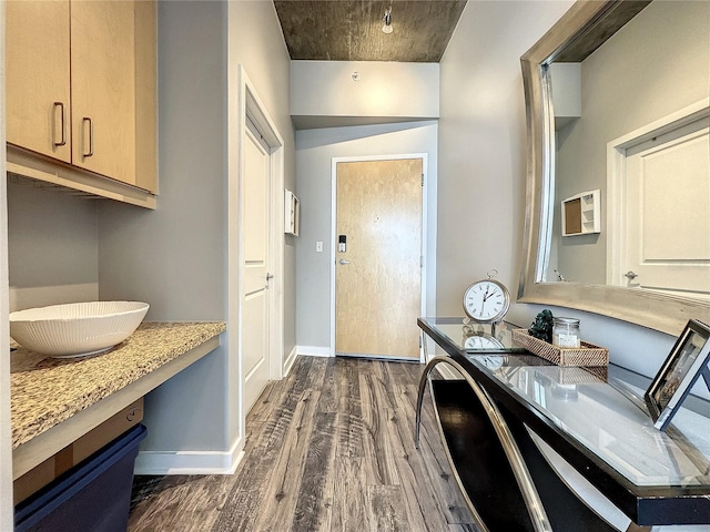 interior space with dark wood-type flooring and baseboards