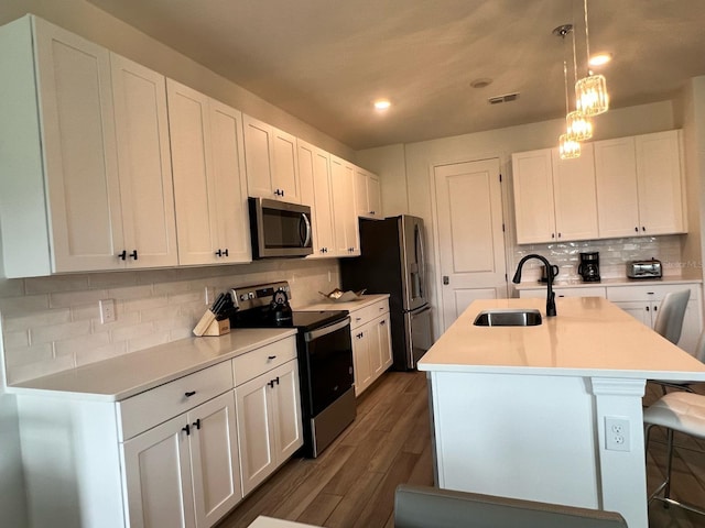 832 Benoi Dr, Davenport, FL 33896 - kitchen with a sink, white cabinetry, a breakfast bar, stainless steel appliances, and a kitchen island with sink