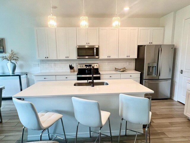 832 Benoi Dr, Davenport, FL 33896 - kitchen with tasteful backsplash, light wood-style floors, a kitchen breakfast bar, and stainless steel appliances