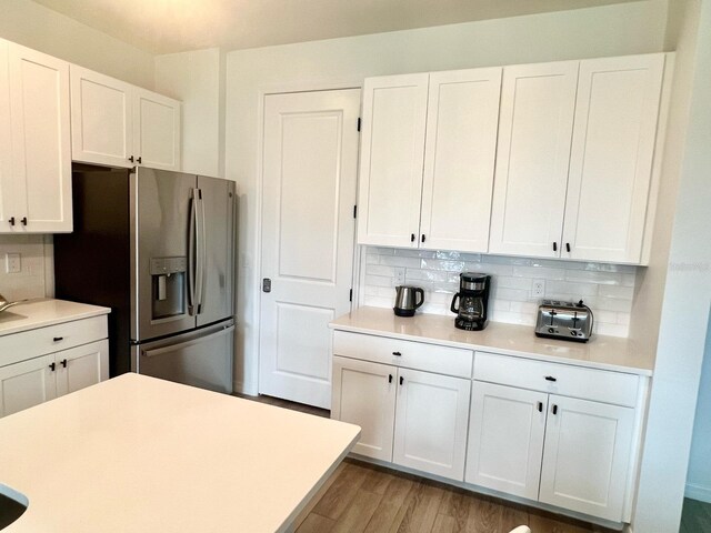 832 Benoi Dr, Davenport, FL 33896 - kitchen featuring white cabinetry, backsplash, light countertops, and stainless steel fridge