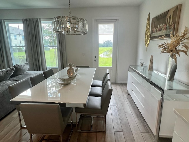 832 Benoi Dr, Davenport, FL 33896 - dining area with light wood-style flooring and an inviting chandelier
