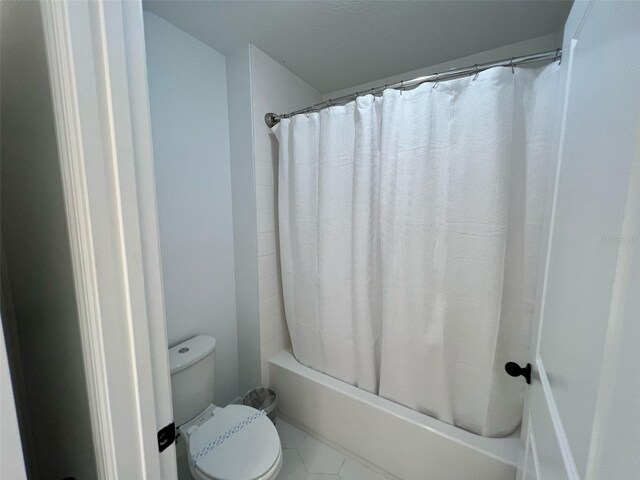 832 Benoi Dr, Davenport, FL 33896 - full bathroom featuring toilet, shower / bath combo with shower curtain, and tile patterned flooring