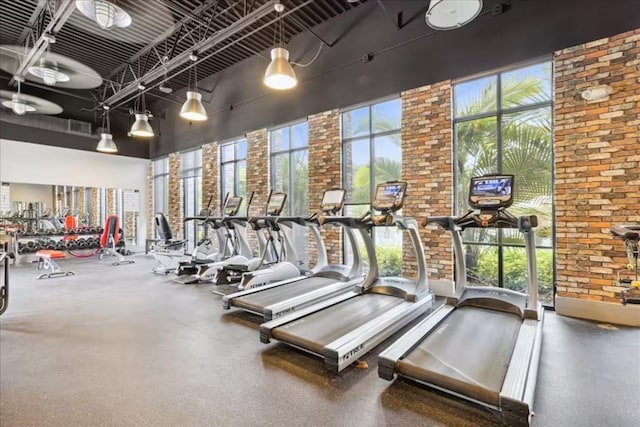 832 Benoi Dr, Davenport, FL 33896 - workout area with visible vents, a high ceiling, and brick wall