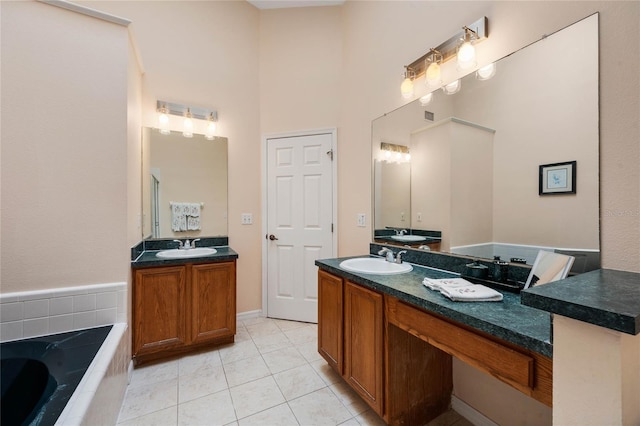 full bathroom featuring tiled bath, a sink, two vanities, and tile patterned flooring