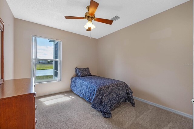bedroom with baseboards, ceiling fan, visible vents, and carpet