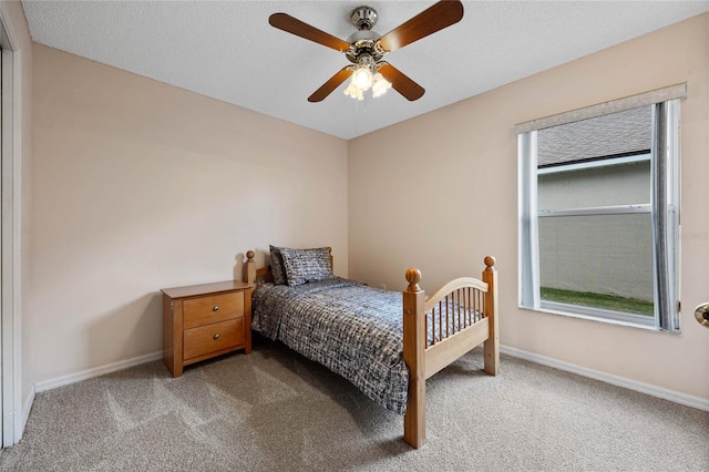 carpeted bedroom featuring baseboards, a textured ceiling, and ceiling fan