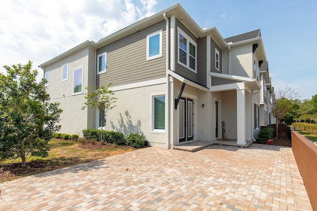 rear view of property featuring stucco siding
