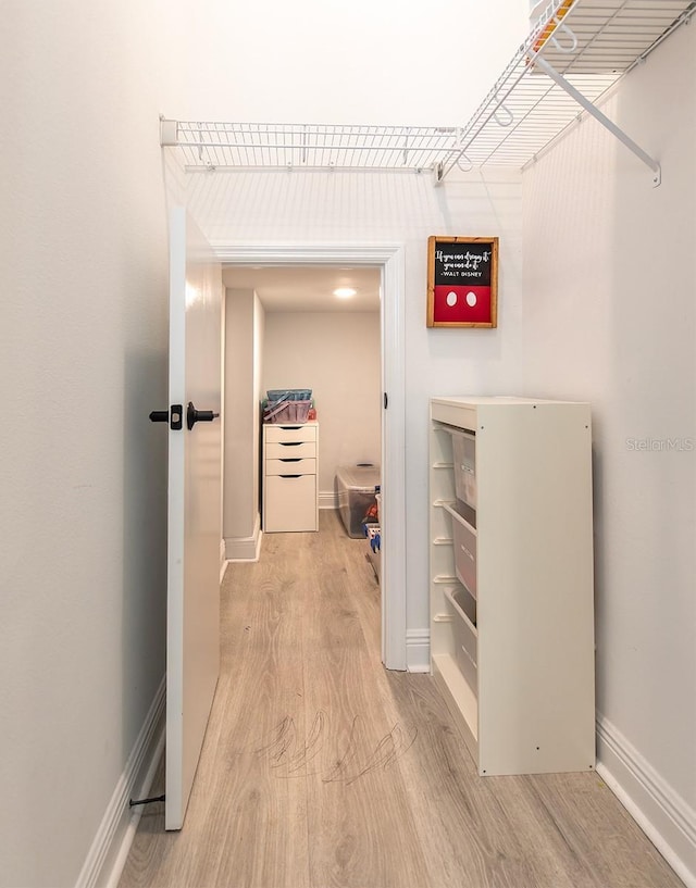 hall with baseboards and light wood-style flooring