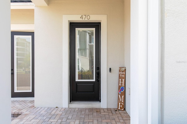 view of exterior entry with stucco siding