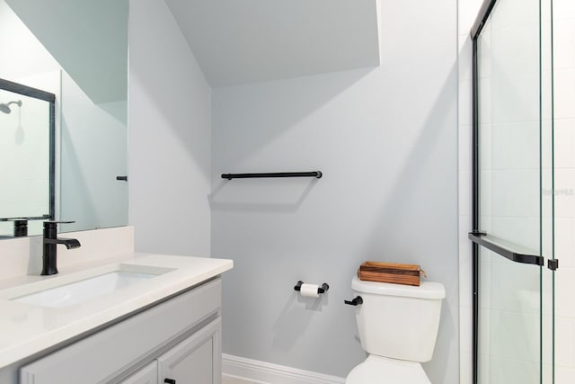 full bathroom with baseboards, a tile shower, toilet, and vanity
