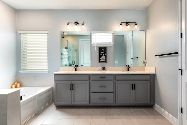 bathroom featuring double vanity, a sink, a bath, and a shower stall