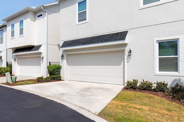 view of front of property with concrete driveway, stucco siding, and an attached garage