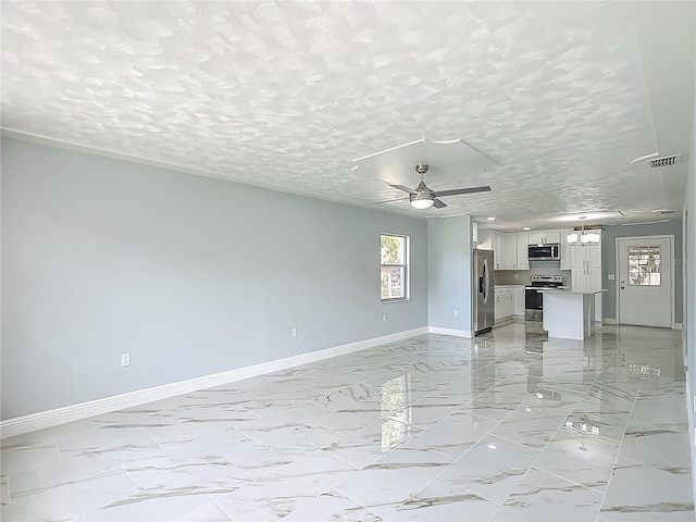 123 Shenandoah Ave, Lady Lake, FL 32159 - unfurnished living room featuring marble finish floor, ceiling fan with notable chandelier, baseboards, and a textured ceiling