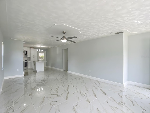 123 Shenandoah Ave, Lady Lake, FL 32159 - unfurnished living room with baseboards, visible vents, a ceiling fan, and a textured ceiling