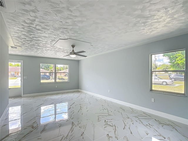 123 Shenandoah Ave, Lady Lake, FL 32159 - unfurnished room with baseboards, marble finish floor, a textured ceiling, and a ceiling fan