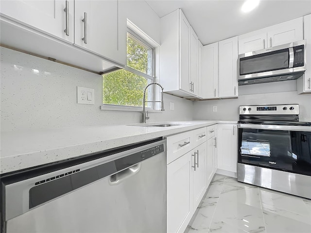 123 Shenandoah Ave, Lady Lake, FL 32159 - kitchen featuring marble finish floor, white cabinets, a sink, and stainless steel appliances