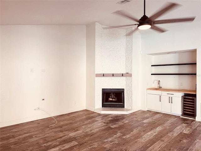7808 The Esplanade Ct, Orlando, FL 32836 - unfurnished living room featuring beverage cooler, wet bar, ceiling fan, and wood finished floors