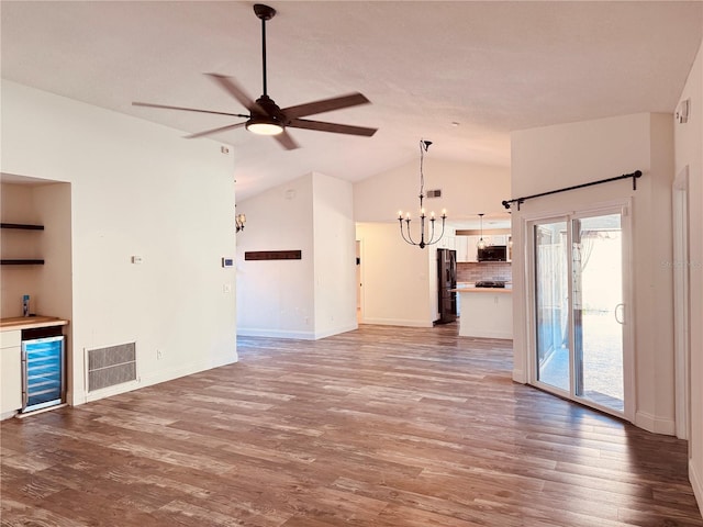7808 The Esplanade Ct, Orlando, FL 32836 - unfurnished living room with beverage cooler, a chandelier, ceiling fan, vaulted ceiling, and wood finished floors