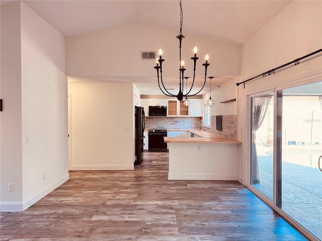 7808 The Esplanade Ct, Orlando, FL 32836 - kitchen featuring stainless steel range oven, a chandelier, freestanding refrigerator, white cabinets, and wood finished floors