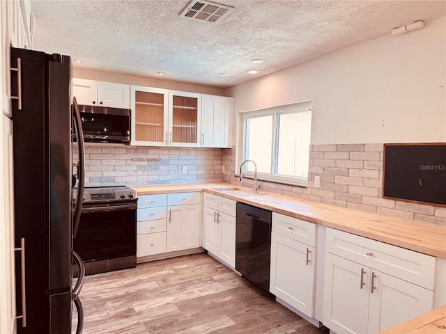 7808 The Esplanade Ct, Orlando, FL 32836 - kitchen featuring stainless steel appliances, butcher block countertops, a textured ceiling, white cabinetry, and recessed lighting