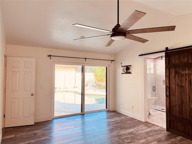 7808 The Esplanade Ct, Orlando, FL 32836 - spare room with a ceiling fan, wood finished floors, a barn door, and vaulted ceiling