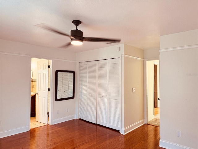 7808 The Esplanade Ct, Orlando, FL 32836 - unfurnished bedroom with wood finished floors, a closet, a ceiling fan, and connected bathroom