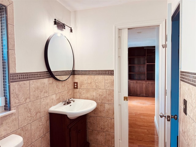 7808 The Esplanade Ct, Orlando, FL 32836 - bathroom featuring tile walls, vanity, wood finished floors, and a wainscoted wall