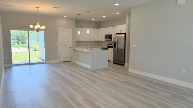 6345 SW 155th Pl, Ocala, FL 34473 - kitchen with stainless steel appliances, a chandelier, baseboards, open floor plan, and a sink