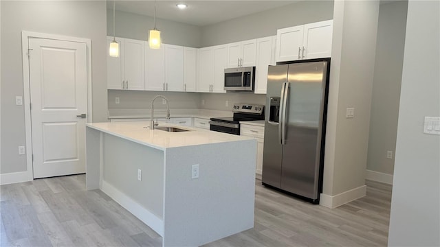 6345 SW 155th Pl, Ocala, FL 34473 - kitchen featuring stainless steel appliances, a sink, white cabinets, light countertops, and hanging light fixtures