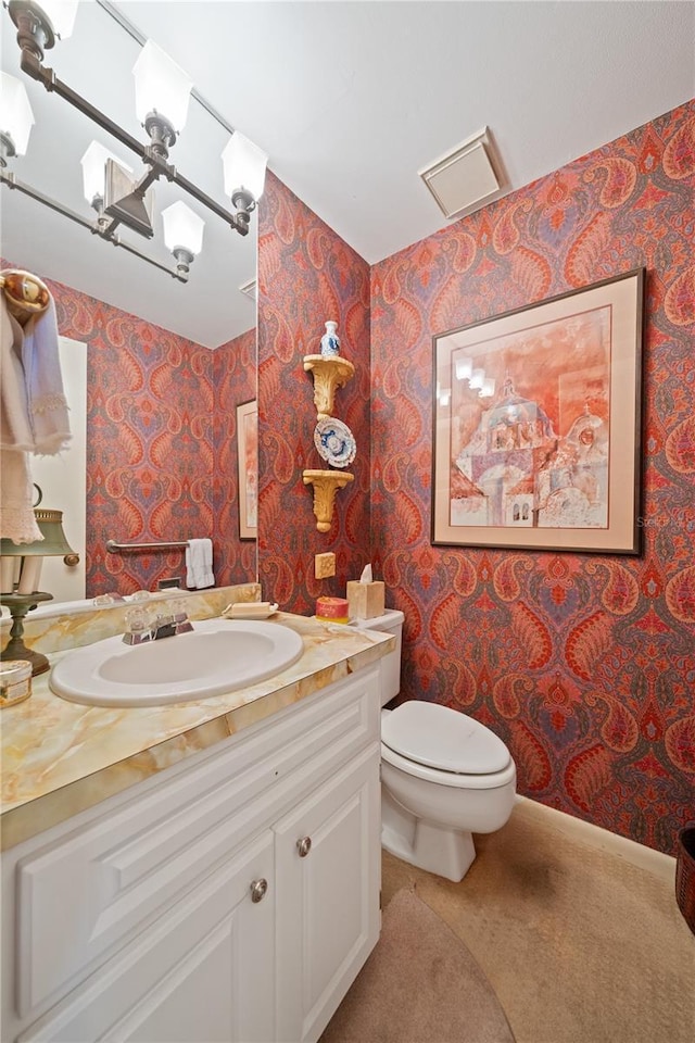 908 Hillary Ct Unit 15, Orlando, FL 32804 - bathroom featuring toilet, wallpapered walls, vanity, and a notable chandelier