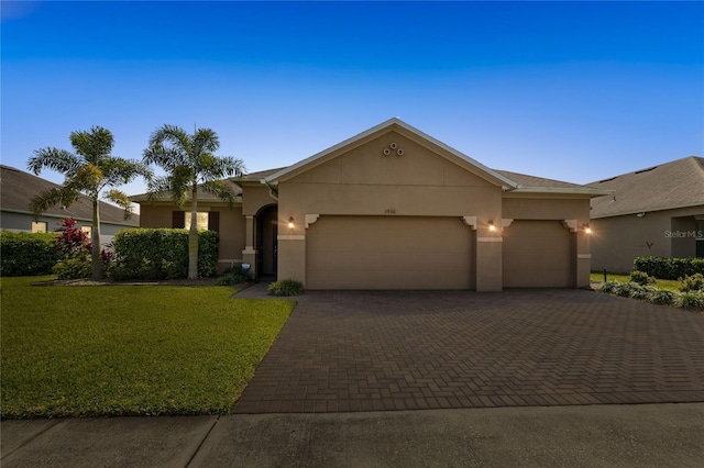 3936 Parkhouse Dr, Orlando, FL 32824 - view of front of property with stucco siding, a garage, a front lawn, and decorative driveway