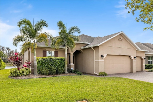 3936 Parkhouse Dr, Orlando, FL 32824 - view of front facade featuring a front yard, stucco siding, and a garage