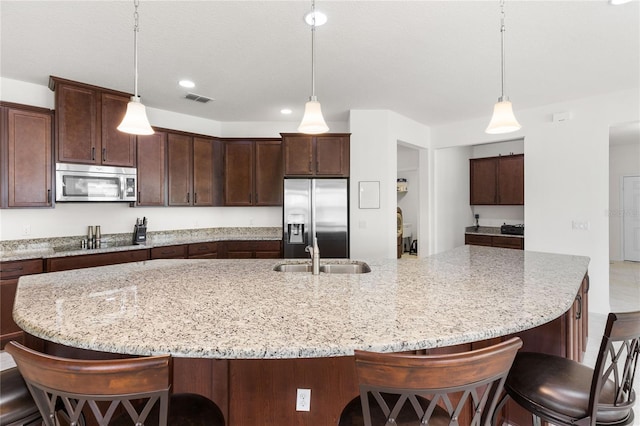 3936 Parkhouse Dr, Orlando, FL 32824 - kitchen with a sink, dark brown cabinets, appliances with stainless steel finishes, and visible vents