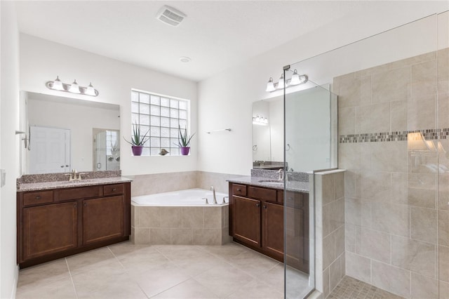 3936 Parkhouse Dr, Orlando, FL 32824 - full bathroom with visible vents, two vanities, a sink, a stall shower, and a garden tub