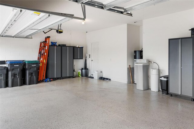 3936 Parkhouse Dr, Orlando, FL 32824 - garage featuring a garage door opener and concrete block wall