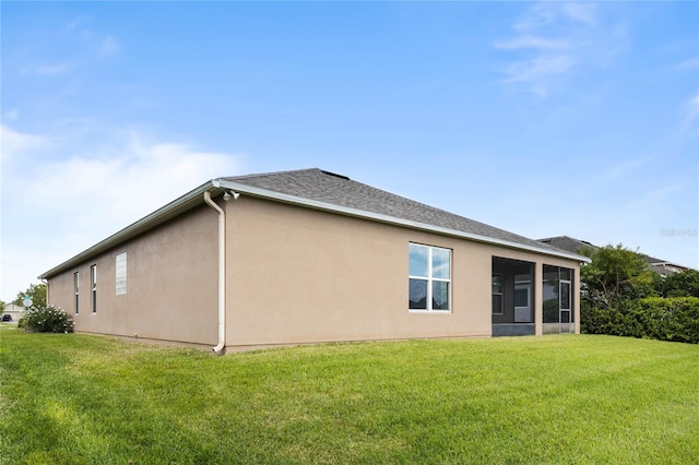 3936 Parkhouse Dr, Orlando, FL 32824 - rear view of property featuring roof with shingles, stucco siding, a sunroom, and a yard