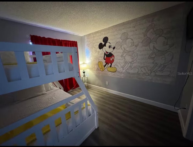 bedroom featuring wood finished floors, baseboards, and a textured ceiling