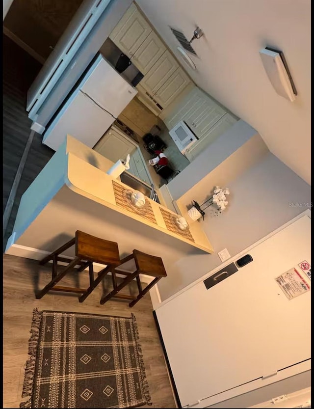 kitchen featuring white microwave and wood finished floors