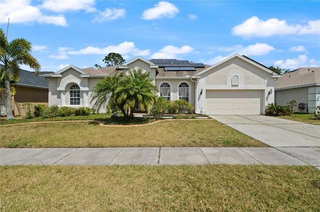 625 Waterland Ct, Orlando, FL 32828 - view of front of property with stucco siding, an attached garage, driveway, a front lawn, and solar panels