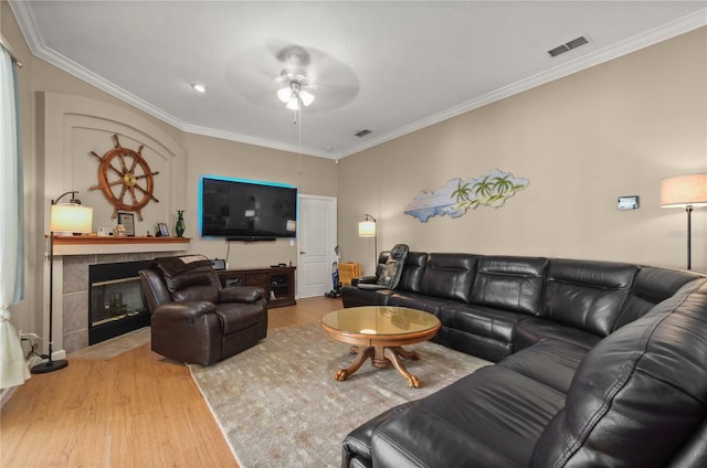 625 Waterland Ct, Orlando, FL 32828 - living room featuring visible vents, a tile fireplace, crown molding, wood finished floors, and a ceiling fan