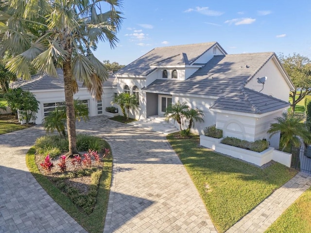 9000 Shawn Park Pl, Orlando, FL 32819 - view of front of property with a front lawn, decorative driveway, a garage, and stucco siding