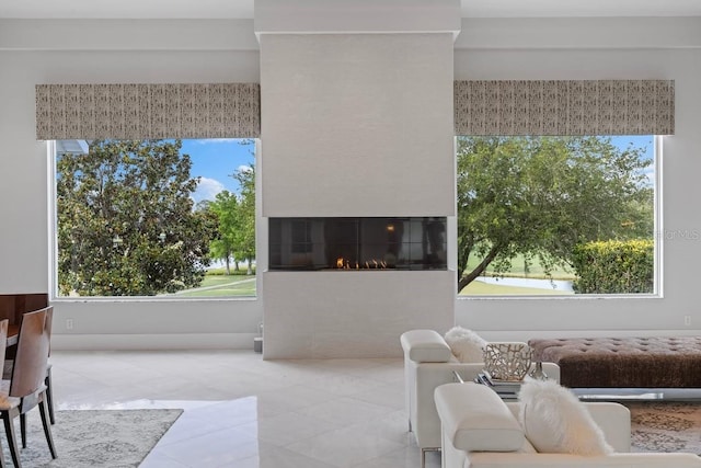 9000 Shawn Park Pl, Orlando, FL 32819 - tiled living area with a glass covered fireplace and a healthy amount of sunlight