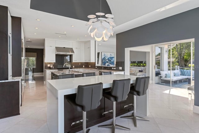 9000 Shawn Park Pl, Orlando, FL 32819 - kitchen with tasteful backsplash, a sink, an island with sink, modern cabinets, and a notable chandelier