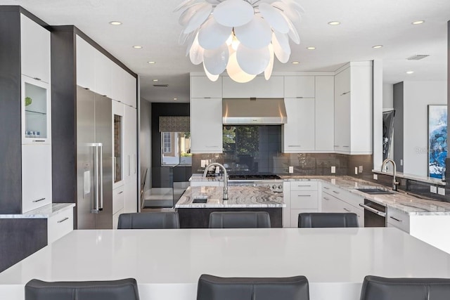9000 Shawn Park Pl, Orlando, FL 32819 - kitchen featuring white cabinetry, wall chimney exhaust hood, a sink, and dishwasher