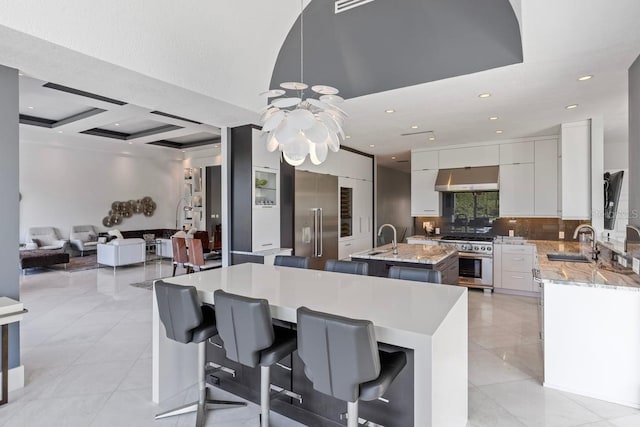 9000 Shawn Park Pl, Orlando, FL 32819 - kitchen with a chandelier, a sink, an island with sink, high end appliances, and ventilation hood