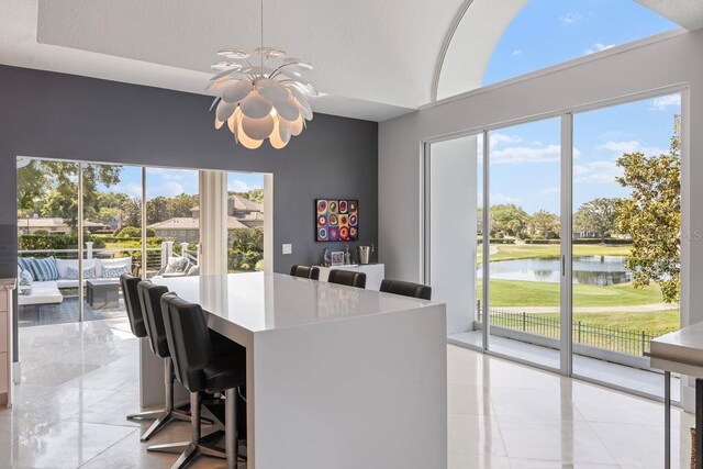 9000 Shawn Park Pl, Orlando, FL 32819 - dining area with light tile patterned flooring, a water view, a wealth of natural light, and an inviting chandelier