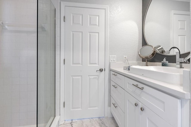 9000 Shawn Park Pl, Orlando, FL 32819 - full bathroom with a textured wall, marble finish floor, a tile shower, and vanity