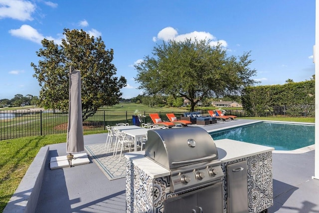9000 Shawn Park Pl, Orlando, FL 32819 - view of swimming pool with a fenced backyard, an outdoor kitchen, area for grilling, and a patio area
